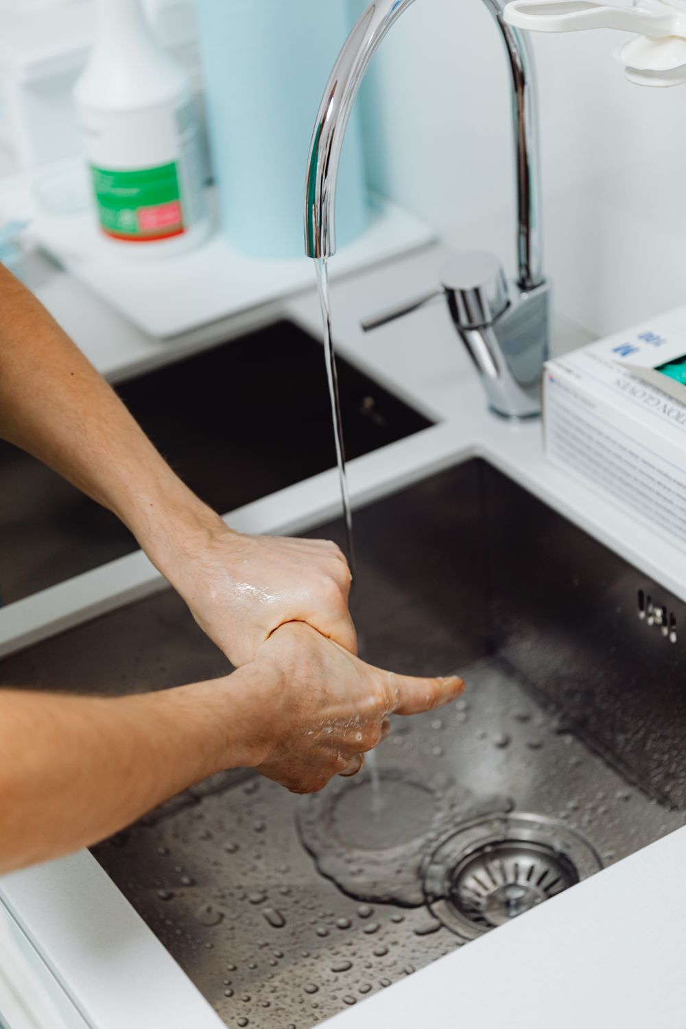 Lavado de manos en el fregadero de acero inoxidable de una cocina profesional
